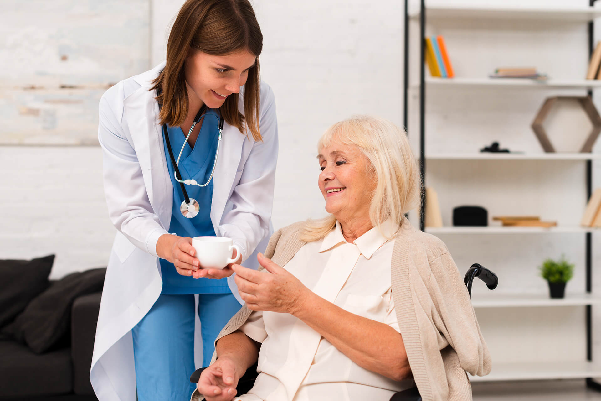 Caregiver offering a beverage on cup to senior - QAL Care